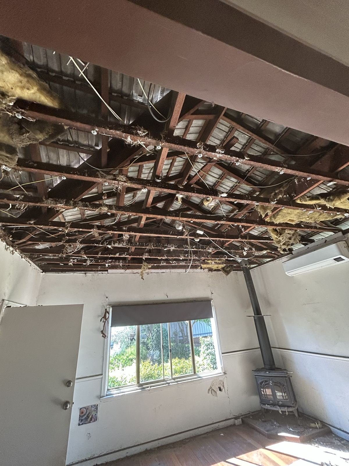Old plasterboard ceiling stripped out in a Perth home, showing exposed framing, old insulation and loose wiring