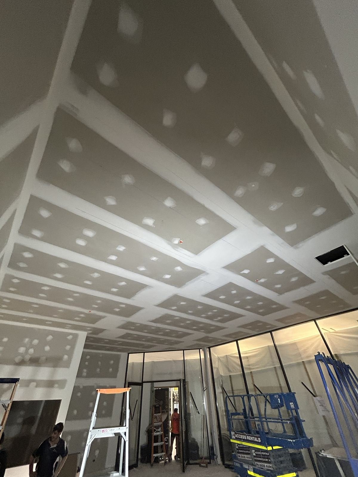 Large commercial ceiling grid set to a paint-ready finish above a glazed shopfront, Perth