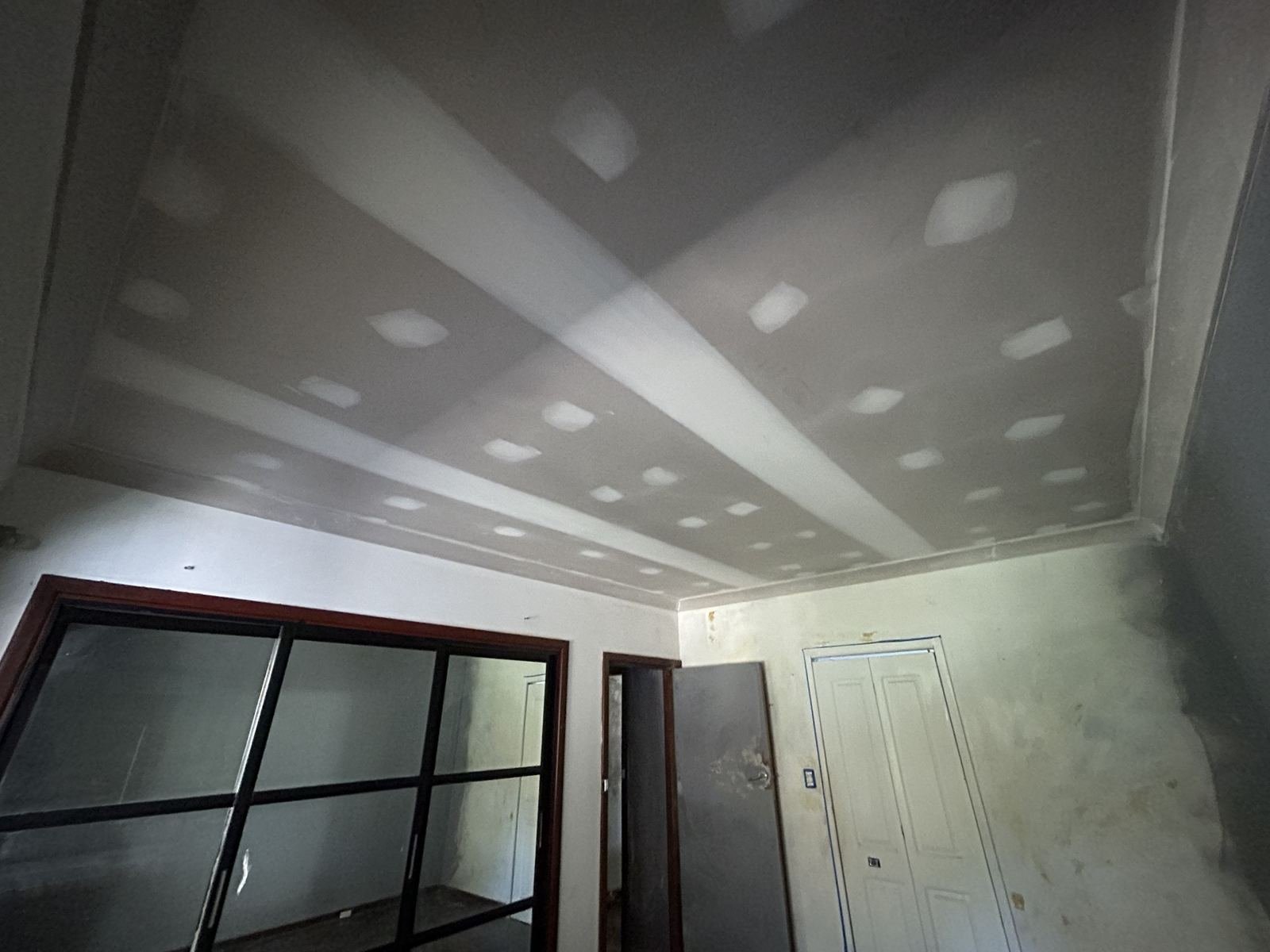New plasterboard ceiling and cornice set in a bedroom, ready for sanding and paint